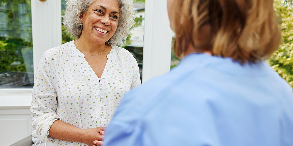 Paciente sonriendo mientras habla con un profesional sanitario. Paciente sonriendo mientras habla con un profesional sanitario.